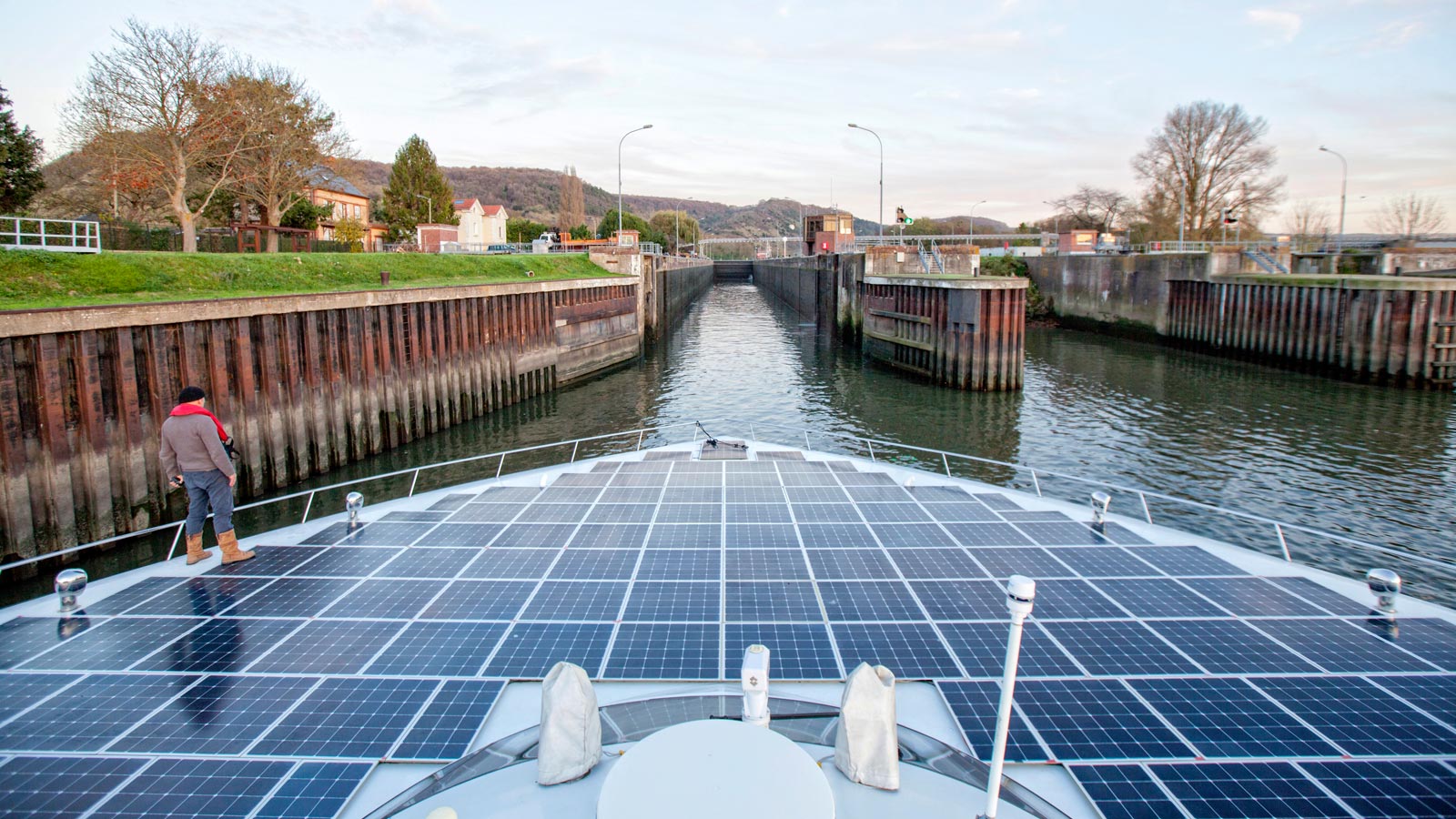 A boat covered with solar panels in a canal