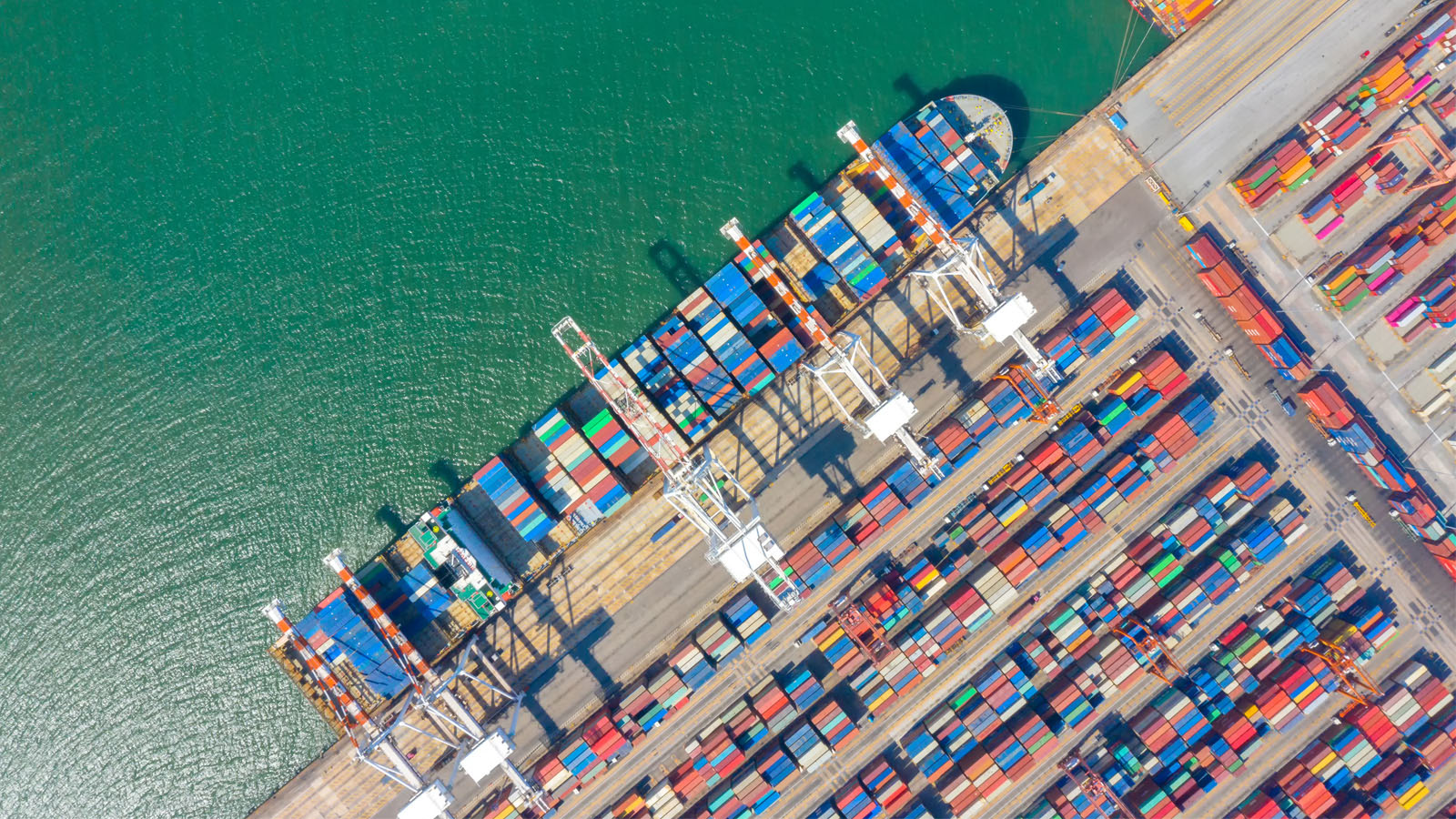 Container ship in export and import business and logistics. Shipping cargo to harbor by crane. Water transport International. Aerial view and top view.