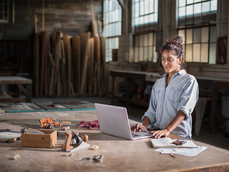 Young Mixed Race Female Entrepreneur Solving a Complicated Business Challenge with Pencil, Laptop, Carpentry Tools, and Confidence 