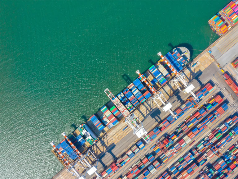 Container ship in export and import business and logistics. Shipping cargo to harbor by crane. Water transport International. Aerial view and top view.