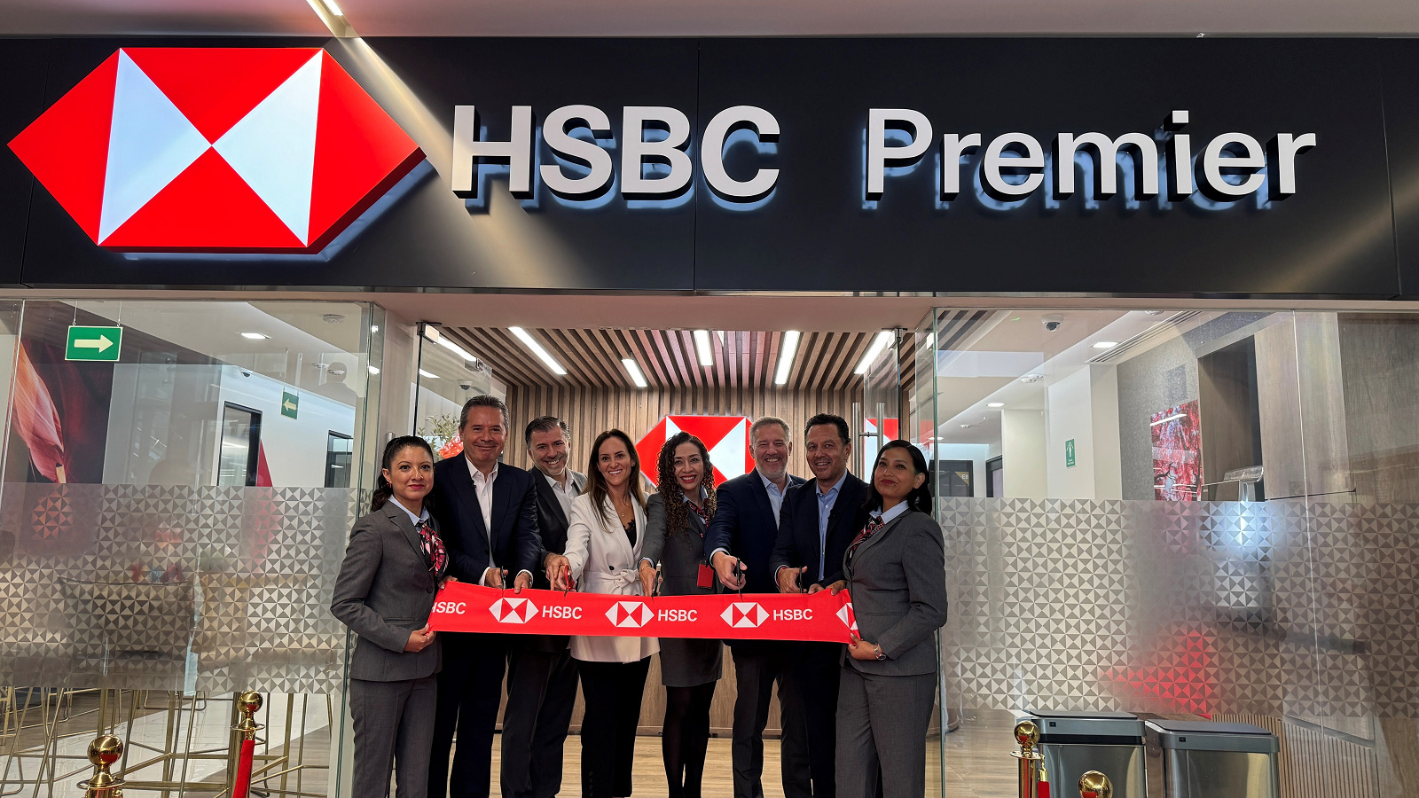 HSBC colleagues cutting a ribbon in the doorway of one of our wealth centres to signal its opening.