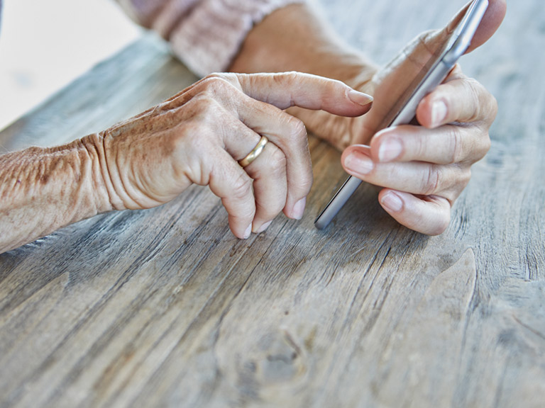 Woman’s hands using smartphone, close-up