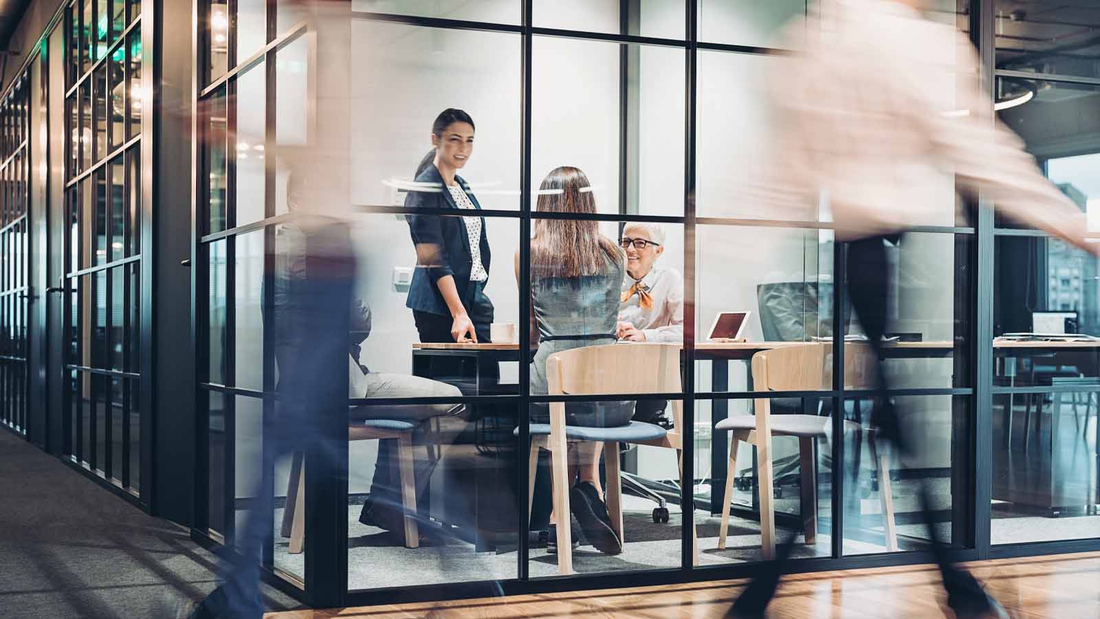 An image of people holding a meeting in a busy office.