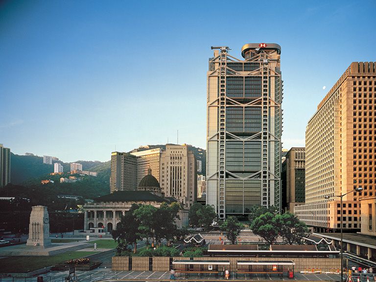 A present-day photo of the front of HSBC headquarters in Hong Kong among neighbouring buildings