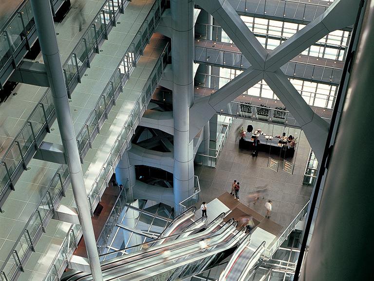 A top-down view of the building's atria from inside, showing escalators and several floors