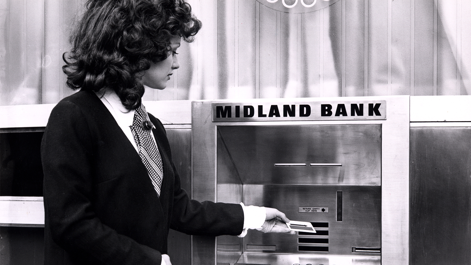 A woman uses a Midland Bank-branded cash machine