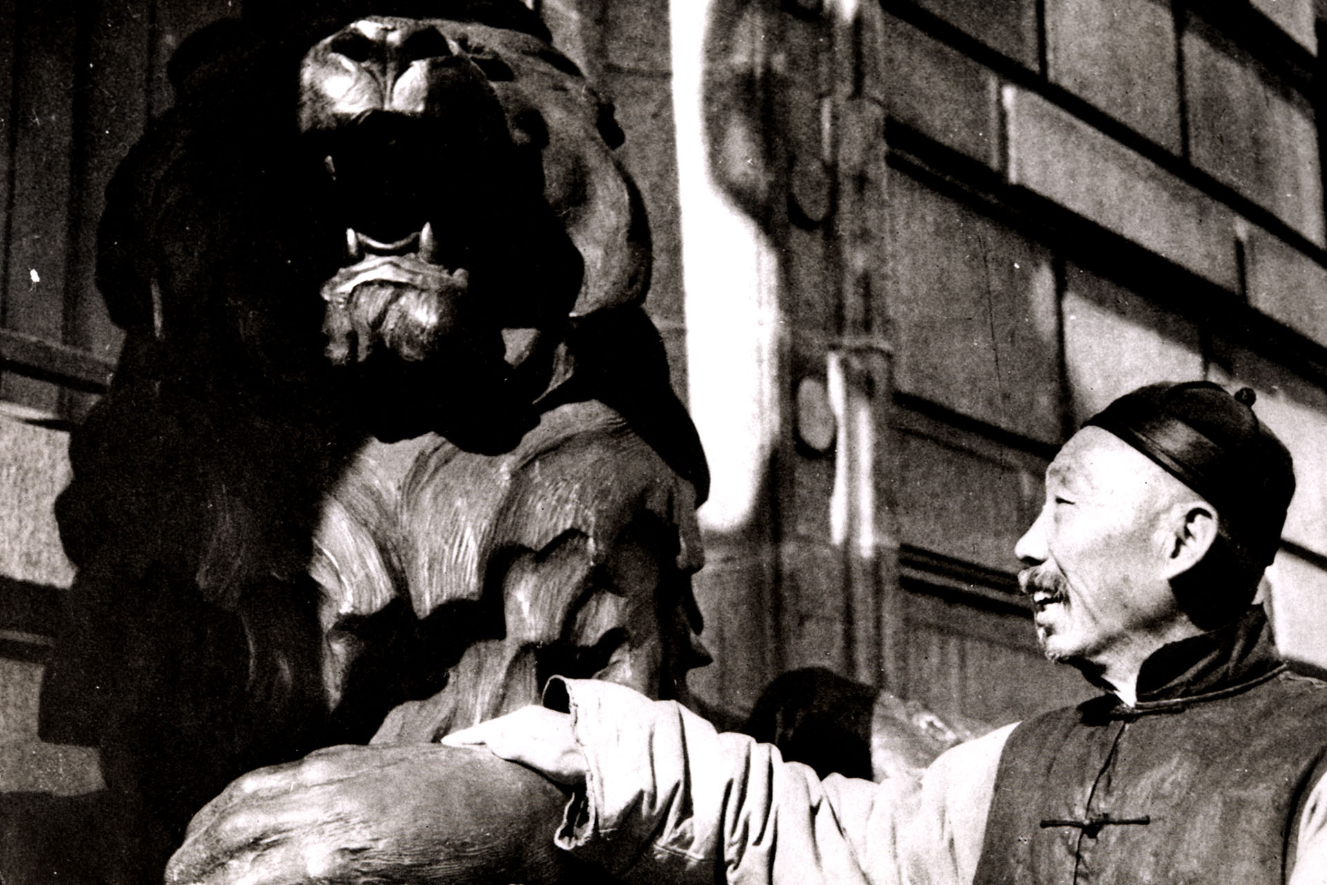 A passer-by strokes the paw of one of the HSBC lions outside the bank’s Shanghai office